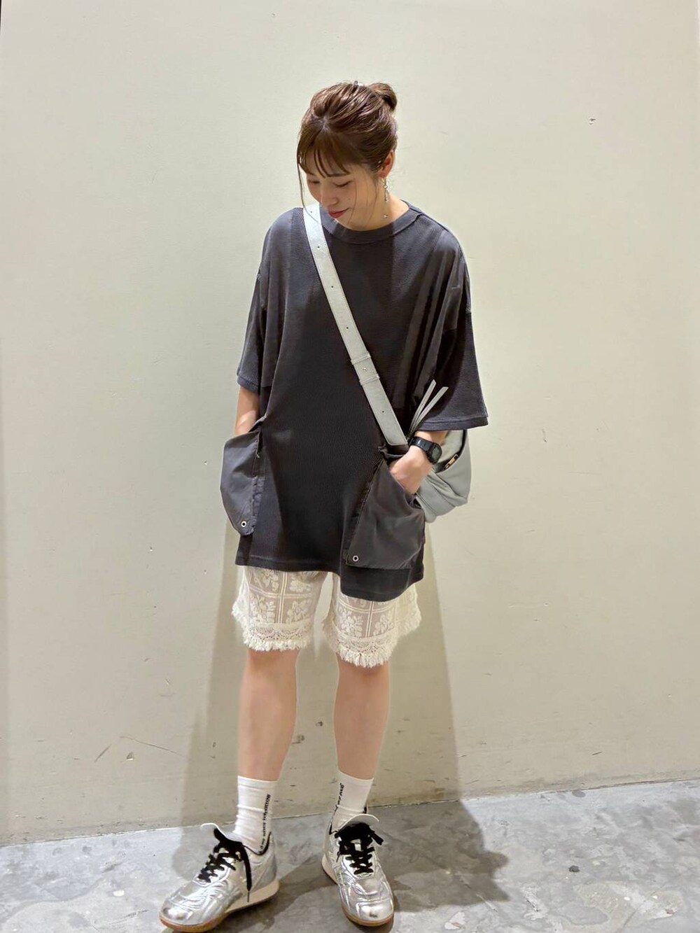 ベージュ系のその他パンツ、シルバー系のスニーカー、グレー系のショルダーバッグを着用したレディースの夏コーディネートの3枚目の写真