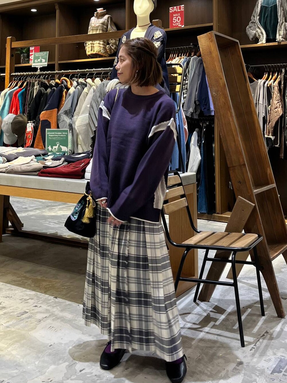 パープル系のニット/セーター、ベージュ系のスカート、その他のパンプスを着用したレディースの冬コーディネートの4枚目の写真