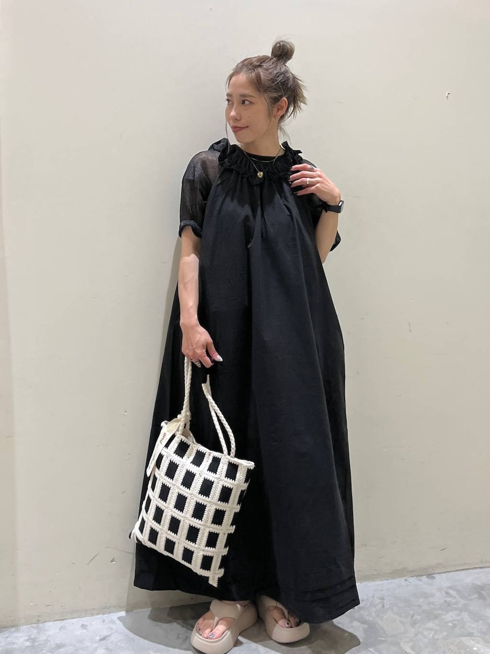 ベージュ系のサンダル、ブラック系のワンピース、ブラック系のトートバッグを着用したレディースの春コーディネートの8枚目の写真
