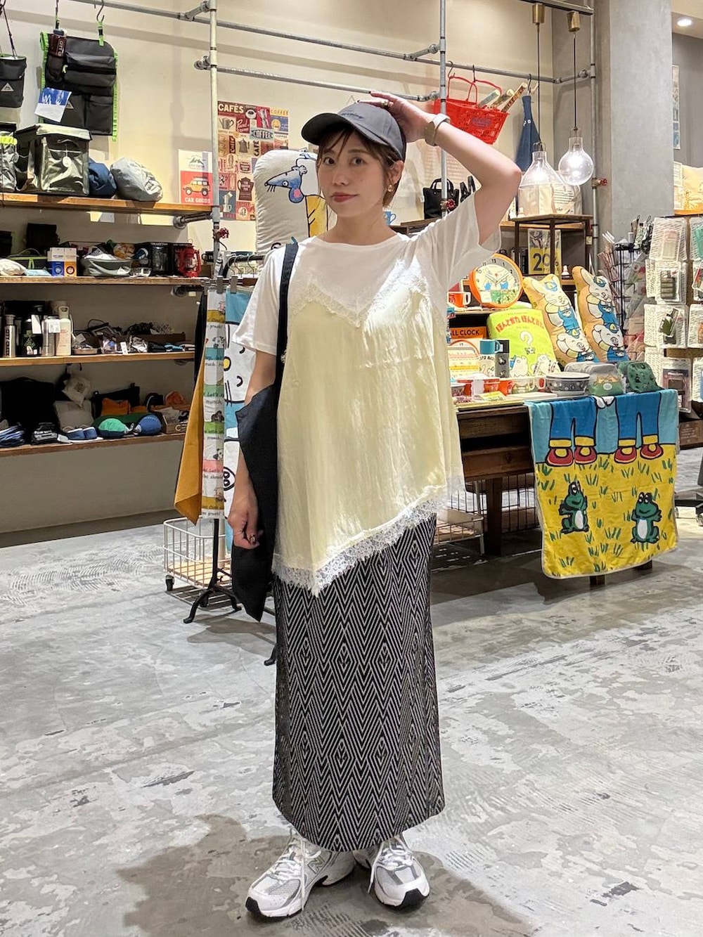 ブラック系のトートバッグ、ブラック系のスカート、ベージュ系のTシャツ/カットソーを着用したレディースの春コーディネートの5枚目の写真