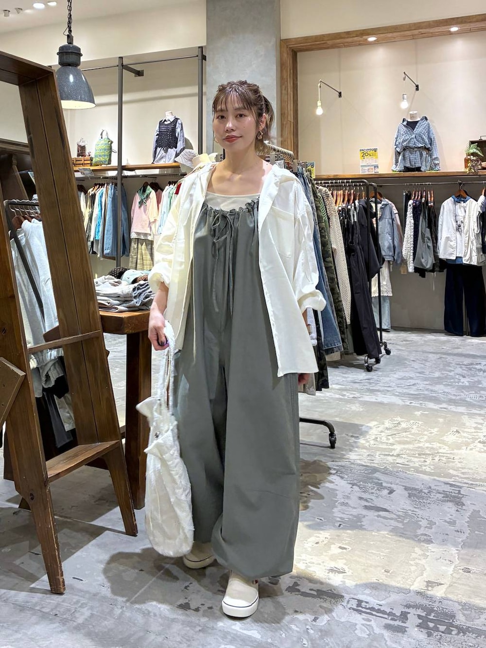 グリーン系のサロペット/オーバーオール、ホワイト系のシャツ/ブラウス、ベージュ系のタンクトップを着用したレディースの春コーディネートの6枚目の写真