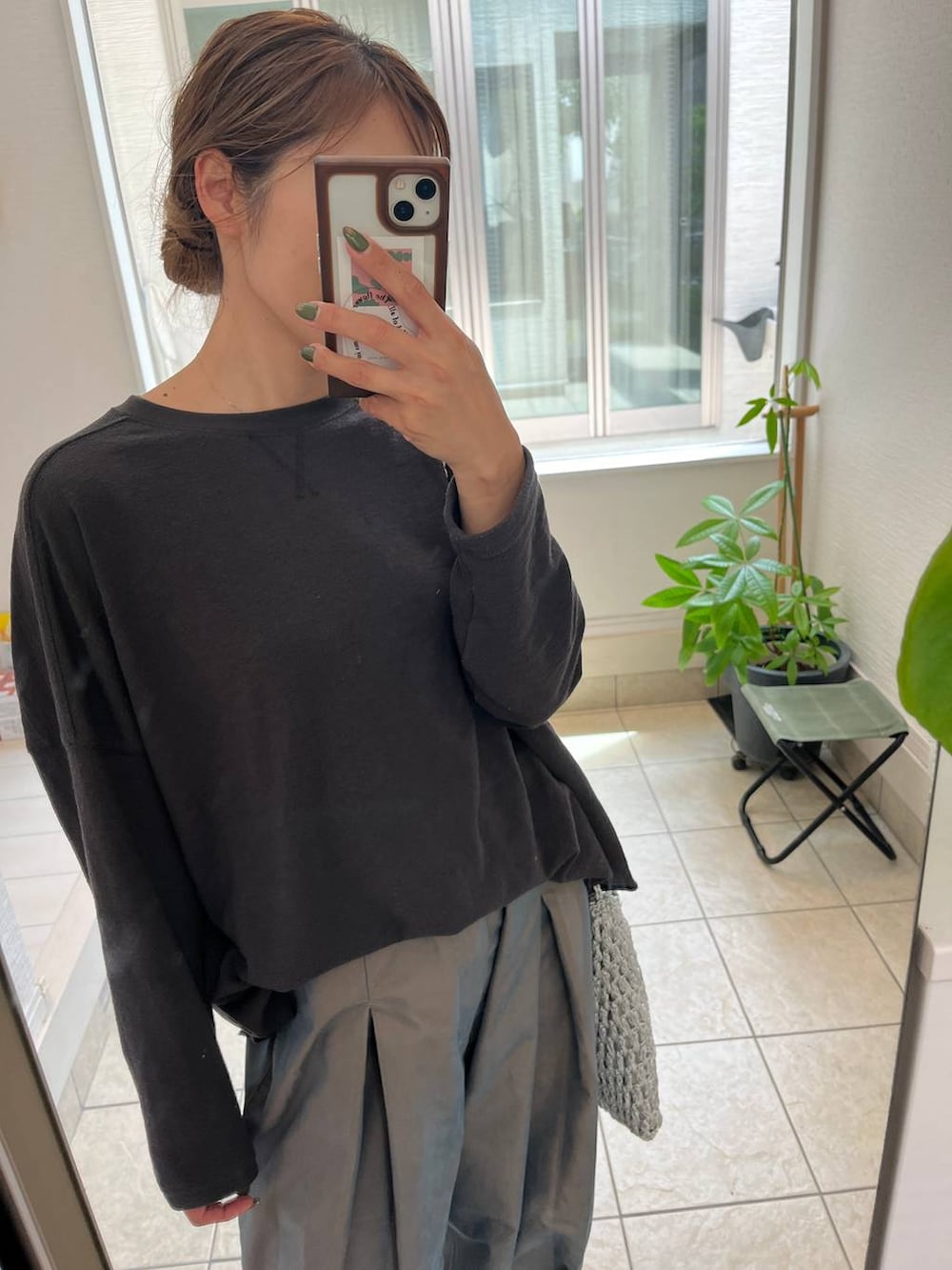 グレー系のショルダーバッグ、シルバー系のパンプス、グリーン系のチノパンツを着用したレディースの夏コーディネートの2枚目の写真