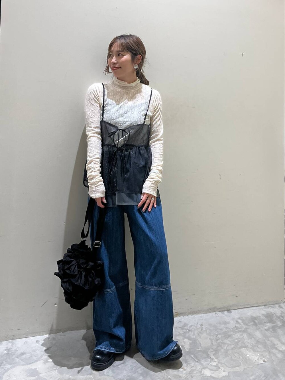 ブラック系のキャミソール、ブラック系のショルダーバッグ、ブラック系のブーツを着用したレディースの冬コーディネートの5枚目の写真