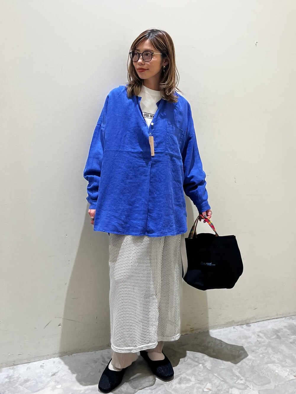 グレー系のスカート、ブラック系のその他シューズ、ブラック系のトートバッグを着用したレディースの春コーディネートの4枚目の写真