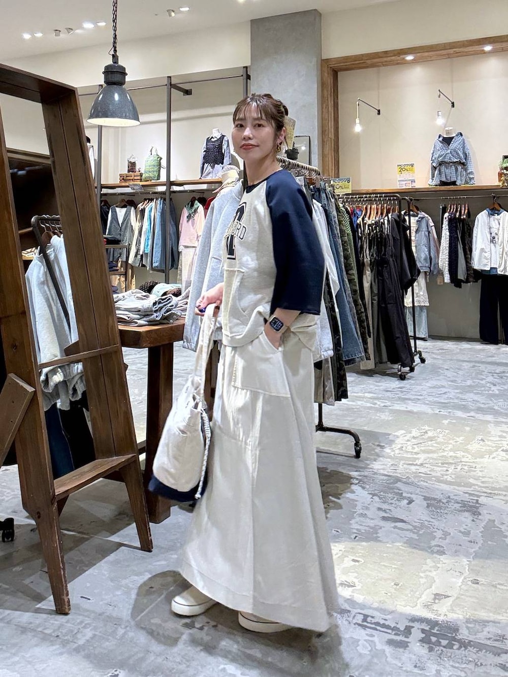 ベージュ系のトートバッグ、ベージュ系のTシャツ/カットソー、ベージュ系のスカートを着用したレディースの春コーディネートの8枚目の写真