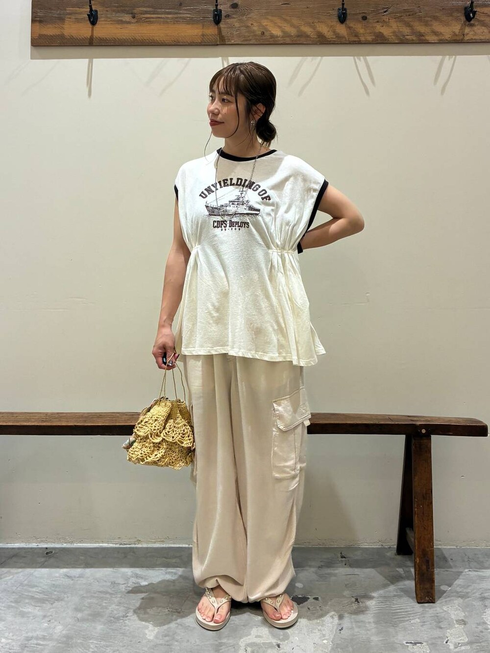 ベージュ系のカーゴパンツ、ベージュ系のショルダーバッグ、ベージュ系のサンダルを着用したレディースの夏コーディネートの2枚目の写真