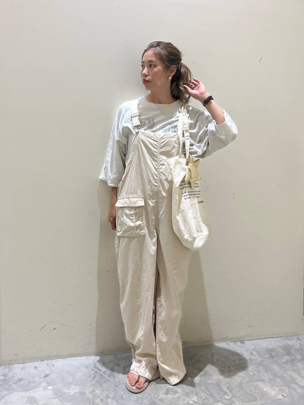 ベージュ系のサロペット/オーバーオール、ベージュ系のTシャツ/カットソー、ベージュ系のサンダルを着用したレディースの夏コーディネートの2枚目の写真