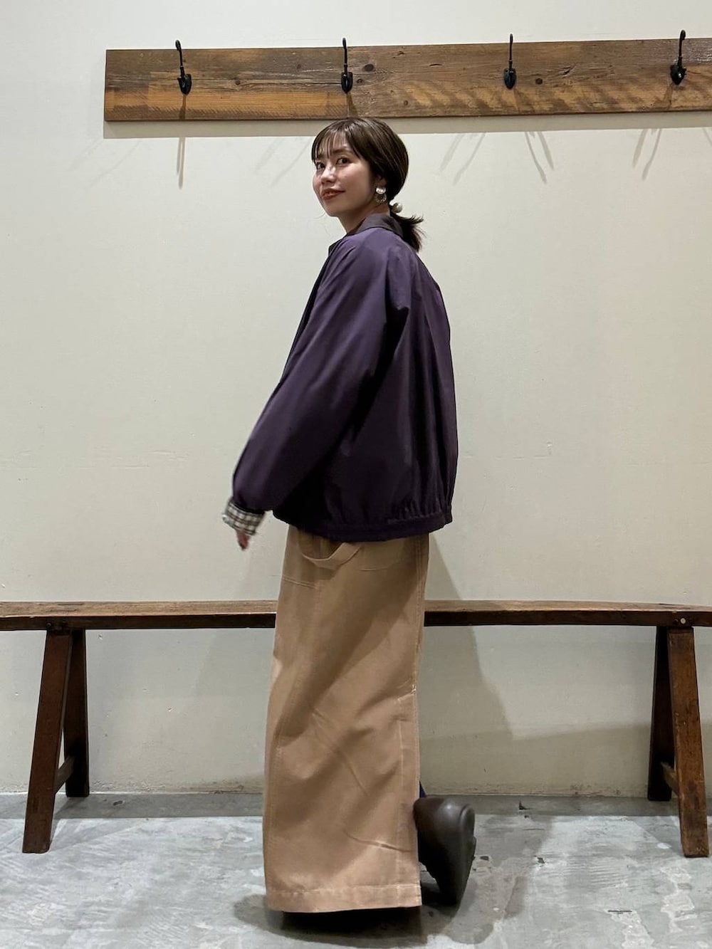 イエロー系のスカート、レッド系のブルゾン、ブラウン系のローファーを着用したレディースの春コーディネートの3枚目の写真