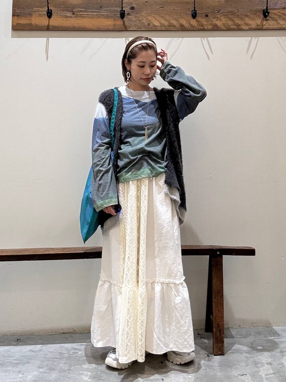 シルバー系のスニーカー、その他のトートバッグ、ベージュ系のスカートを着用したレディースの秋コーディネートの3枚目の写真