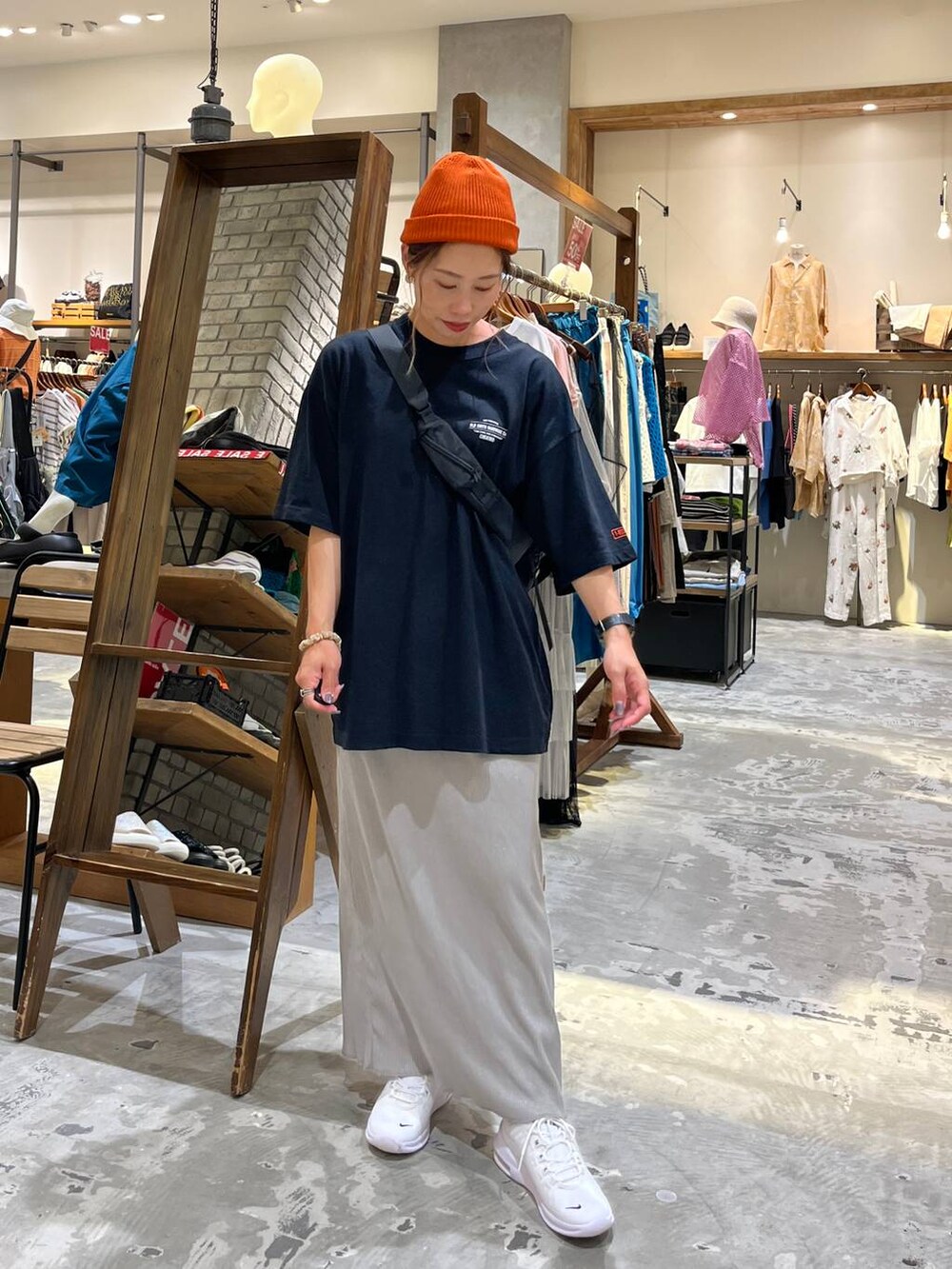 ブラック系のショルダーバッグ、グレー系のスカート、ブラック系のTシャツ/カットソーを着用したレディースの夏コーディネートの5枚目の写真