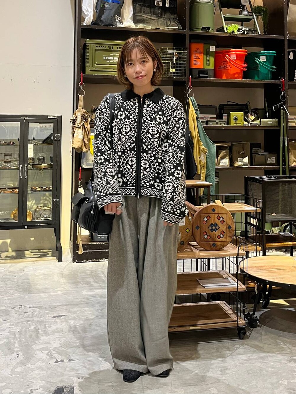 グレー系のその他パンツ、ベージュ系のTシャツ/カットソー、ブラック系のブーツを着用したレディースの冬コーディネートの4枚目の写真