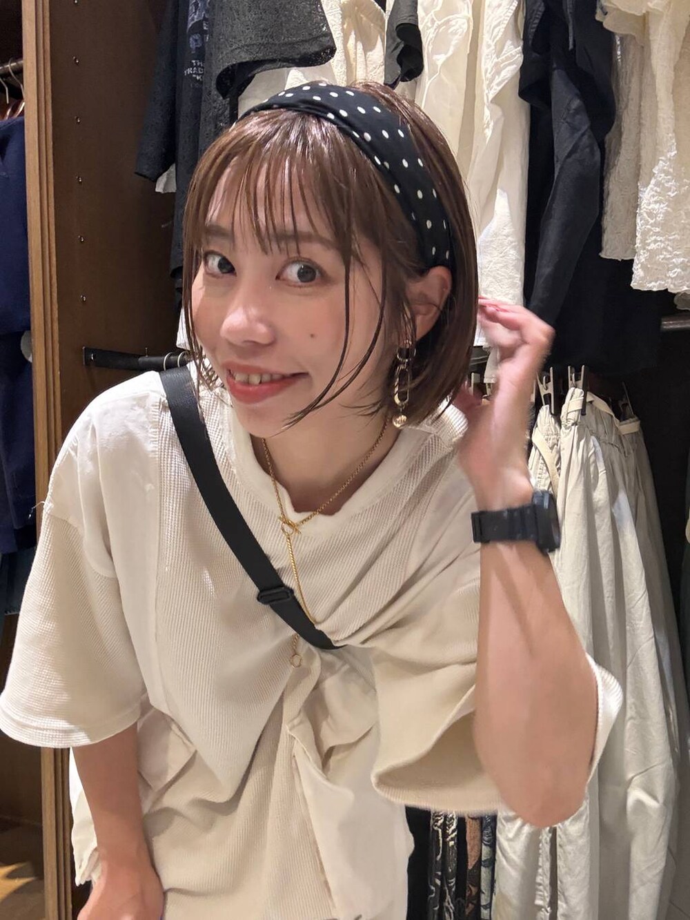 グレー系のスカート、ベージュ系のTシャツ/カットソー、ブラック系のショルダーバッグを着用したレディースの夏コーディネートの7枚目の写真