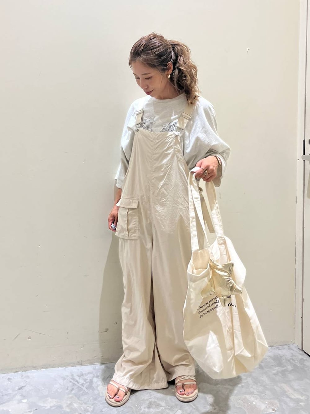 ベージュ系のサロペット/オーバーオール、ベージュ系のTシャツ/カットソー、ベージュ系のサンダルを着用したレディースの夏コーディネートの9枚目の写真