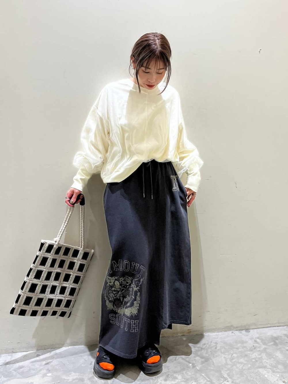 ホワイト系のスウェット、ブラック系のトートバッグ、その他のスカートを着用したレディースの春コーディネートの3枚目の写真