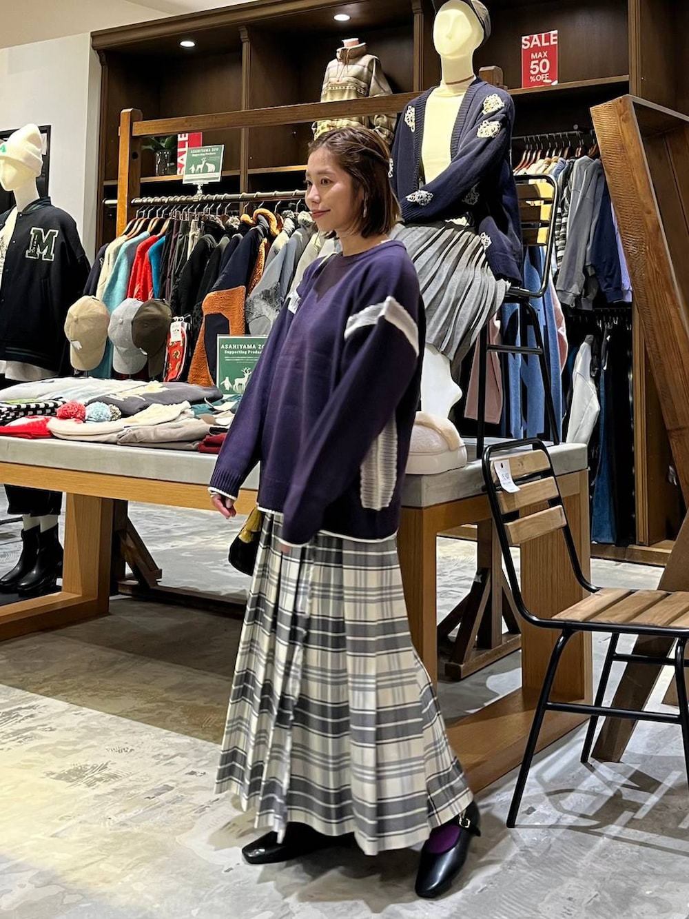 パープル系のニット/セーター、ベージュ系のスカート、その他のパンプスを着用したレディースの冬コーディネートの6枚目の写真