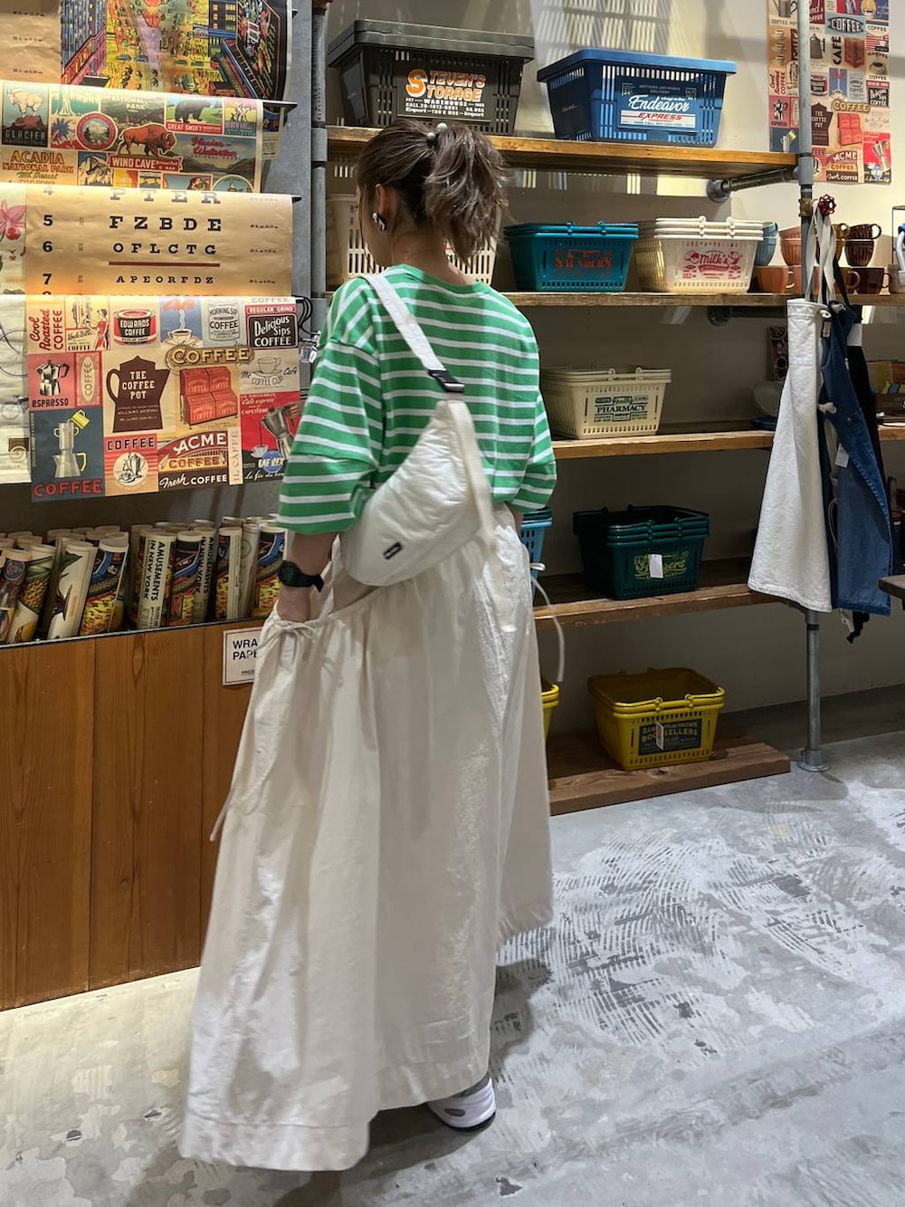 ベージュ系のスカート、ホワイト系のショルダーバッグ、グリーン系のTシャツ/カットソーを着用したレディースの春コーディネートの9枚目の写真