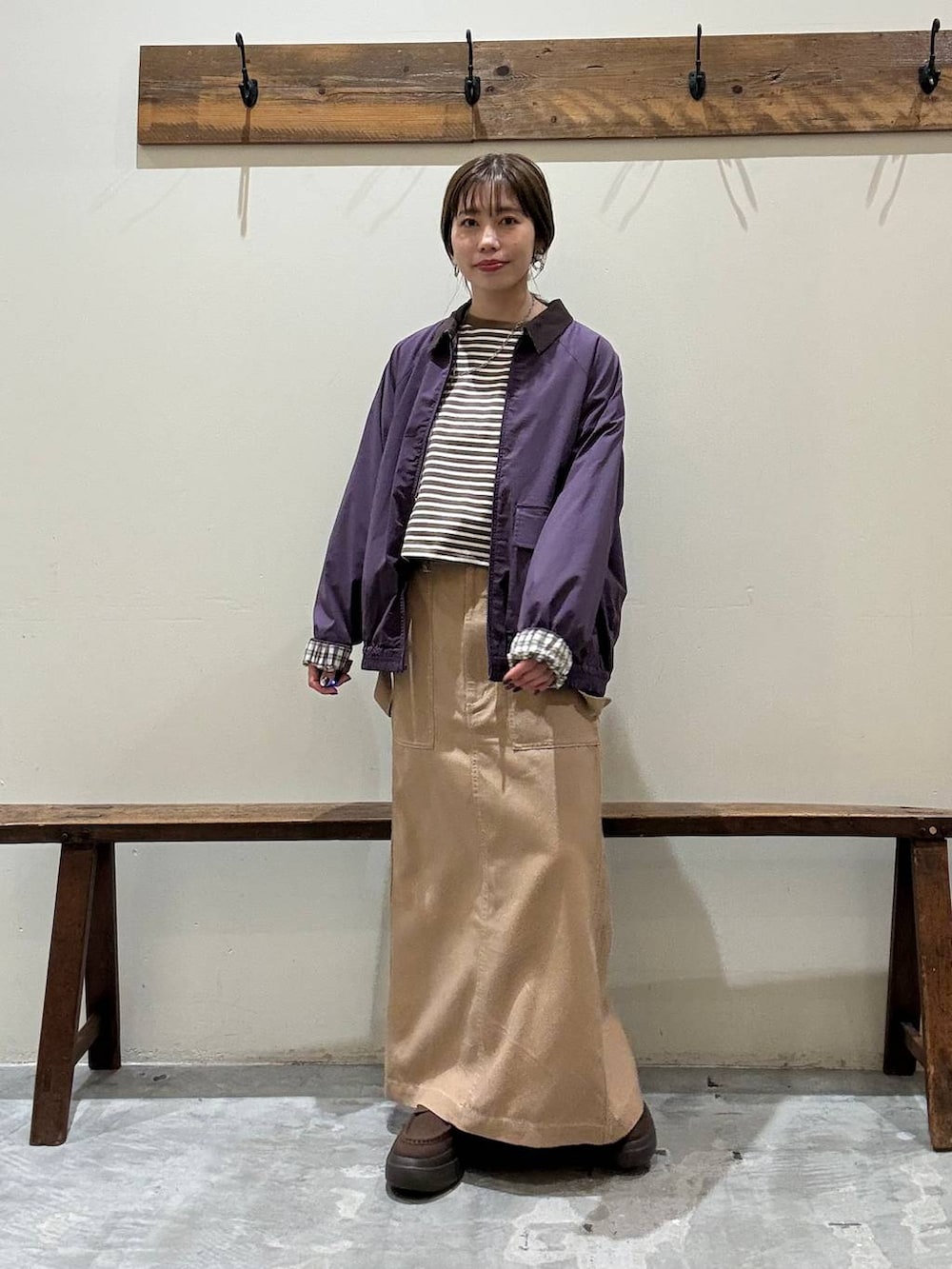 イエロー系のスカート、レッド系のブルゾン、ブラウン系のローファーを着用したレディースの春コーディネートの5枚目の写真