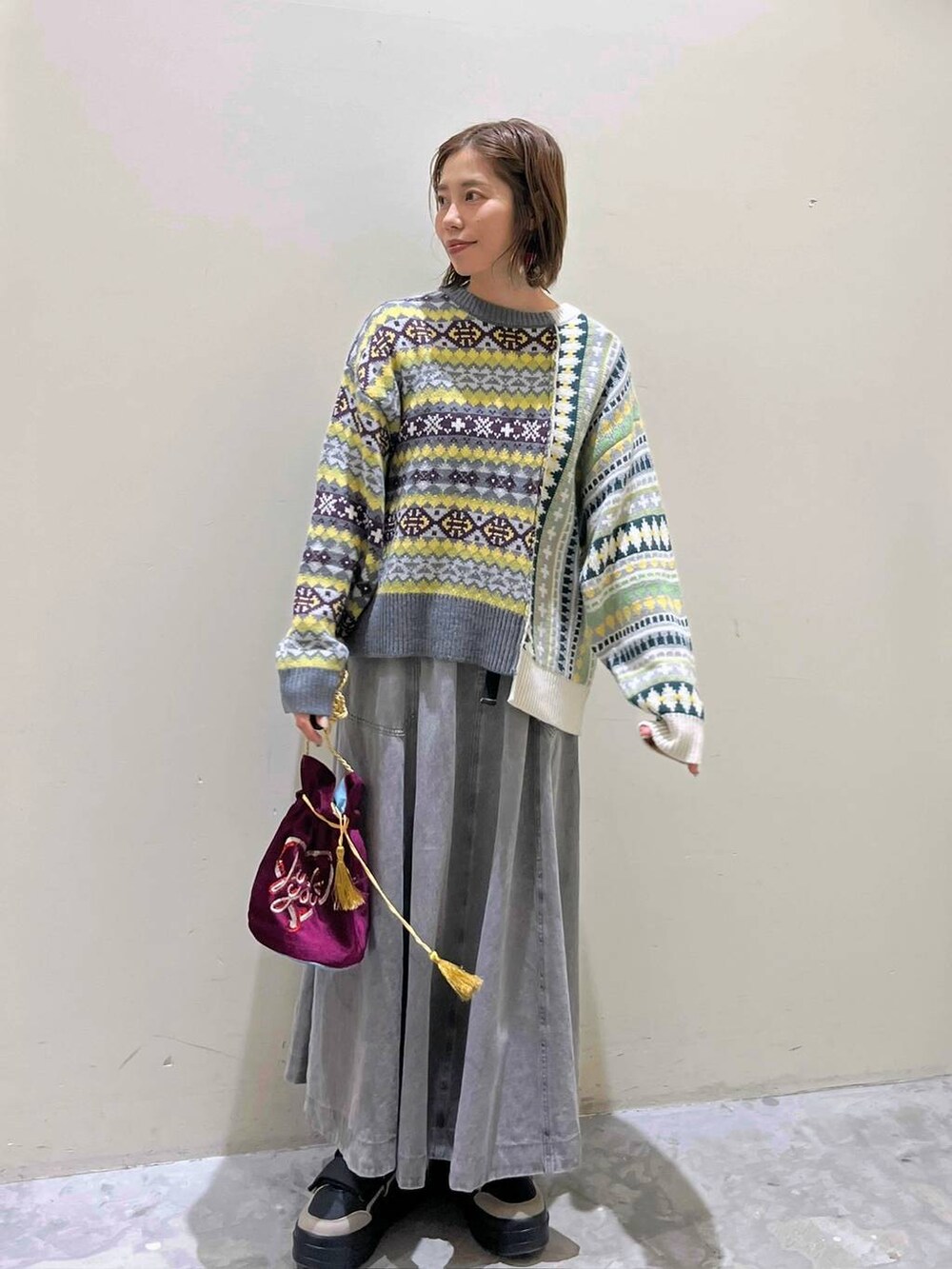 グレー系のスカート、その他のショルダーバッグ、ブラック系のスニーカーを着用したレディースの冬コーディネートの2枚目の写真