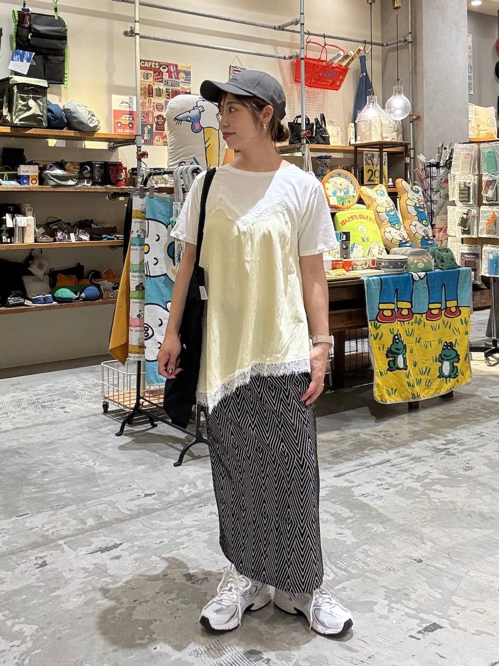 ブラック系のトートバッグ、ブラック系のスカート、ベージュ系のTシャツ/カットソーを着用したレディースの春コーディネートの2枚目の写真