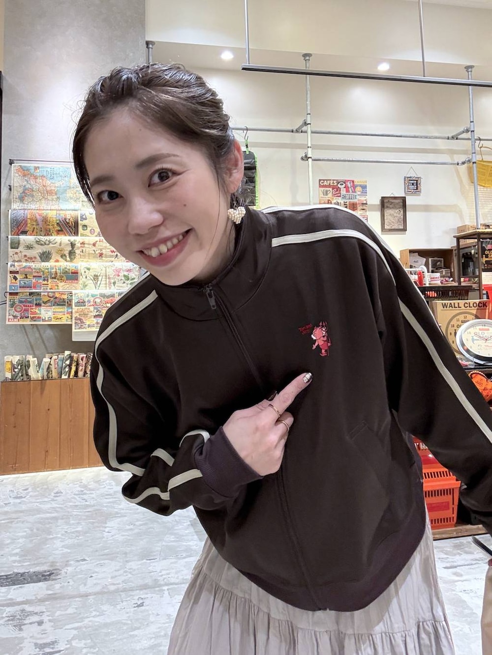 ブラウン系のジャージ、ベージュ系のトートバッグ、グレー系のスニーカーを着用したレディースの春コーディネートの2枚目の写真