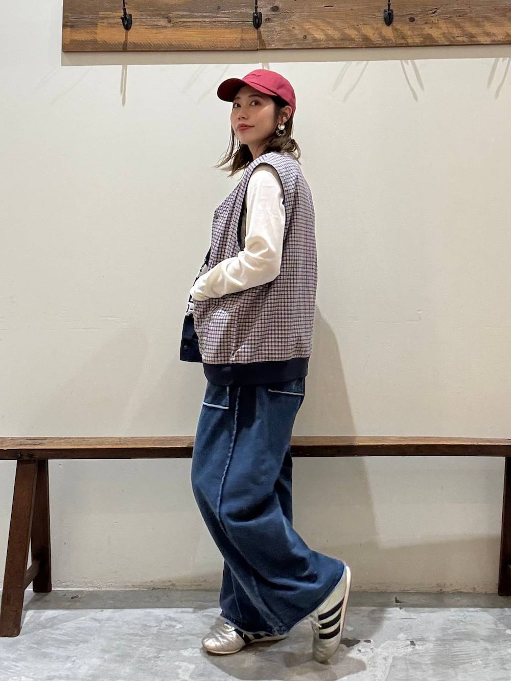 ゴールド系のスニーカー、ベージュ系のTシャツ/カットソー、ブルー系のベストを着用したレディースの冬コーディネートの6枚目の写真