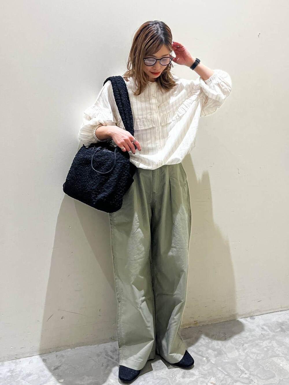 ブラック系のショルダーバッグ、ブラック系のその他シューズ、ベージュ系のシャツ/ブラウスを着用したレディースの春コーディネートの2枚目の写真