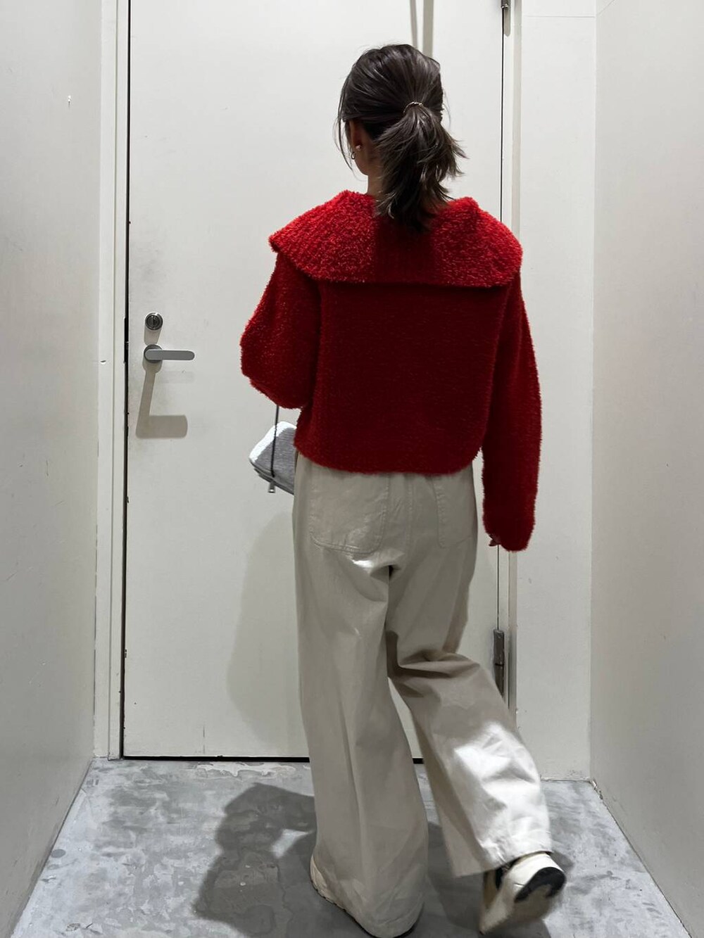 ベージュ系のその他パンツ、グレー系のショルダーバッグ、レッド系のカーディガン/ボレロを着用したレディースの冬コーディネートの3枚目の写真