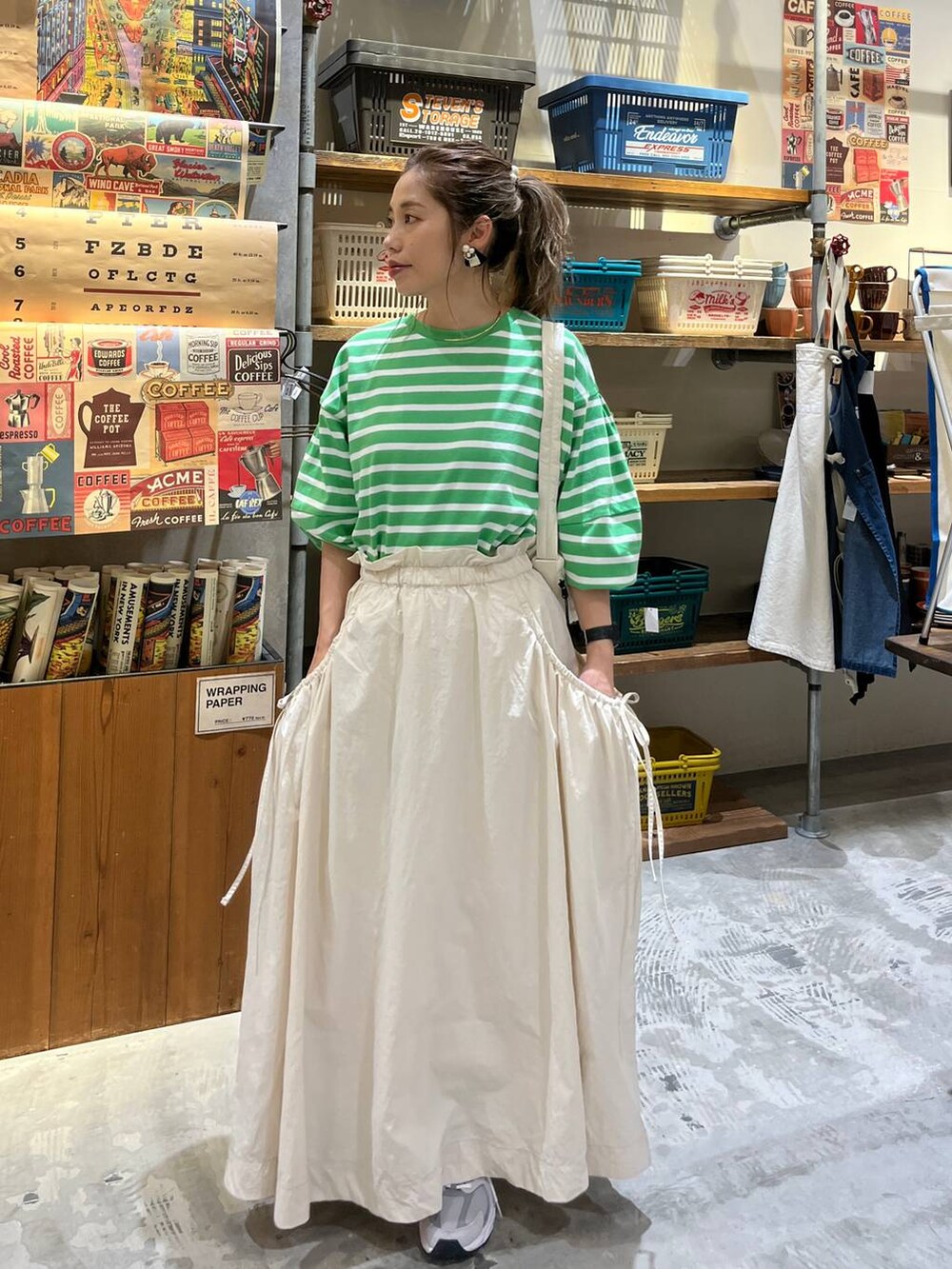 ベージュ系のスカート、ホワイト系のショルダーバッグ、グリーン系のTシャツ/カットソーを着用したレディースの春コーディネートの8枚目の写真