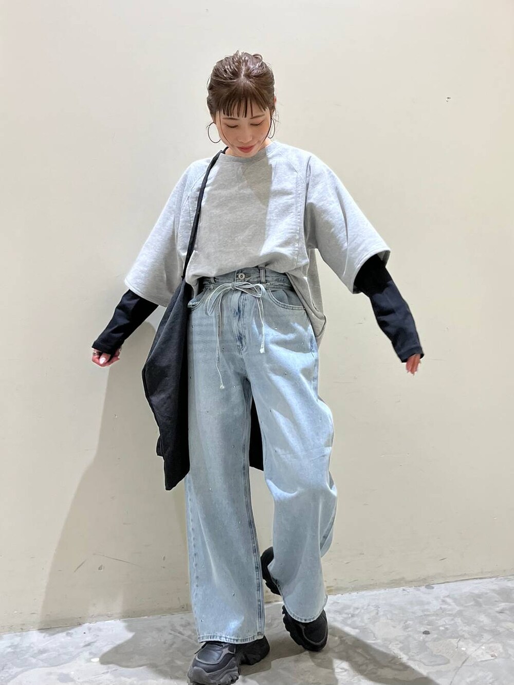 グレー系のトートバッグ、グレー系のTシャツ/カットソー、ブルー系のデニムパンツを着用したレディースの春コーディネートの5枚目の写真