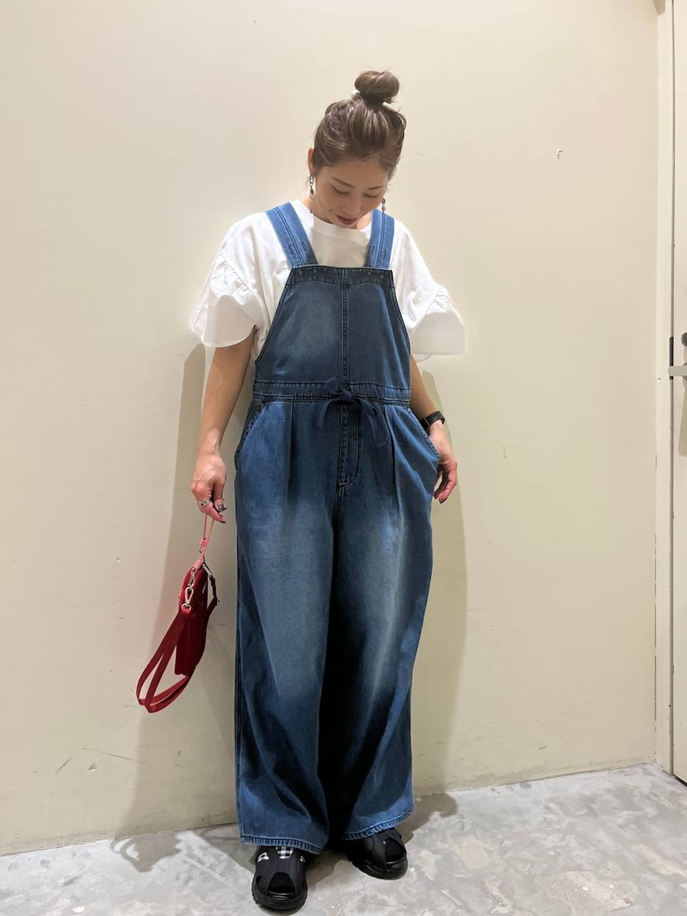 ホワイト系のTシャツ/カットソー、ブラック系のサンダル、レッド系のショルダーバッグを着用したレディースの春コーディネートの2枚目の写真