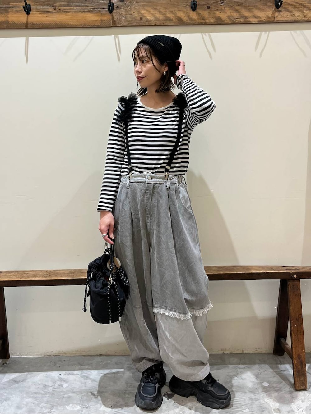 グレー系のデニムパンツ、ブラック系のショルダーバッグ、ブラック系のサスペンダーを着用したレディースの冬コーディネートの3枚目の写真