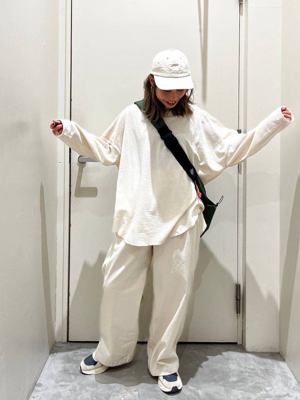 ベージュ系のその他パンツ、ベージュ系のTシャツ/カットソー、グリーン系のショルダーバッグを着用したレディースの冬コーディネートの3枚目の写真