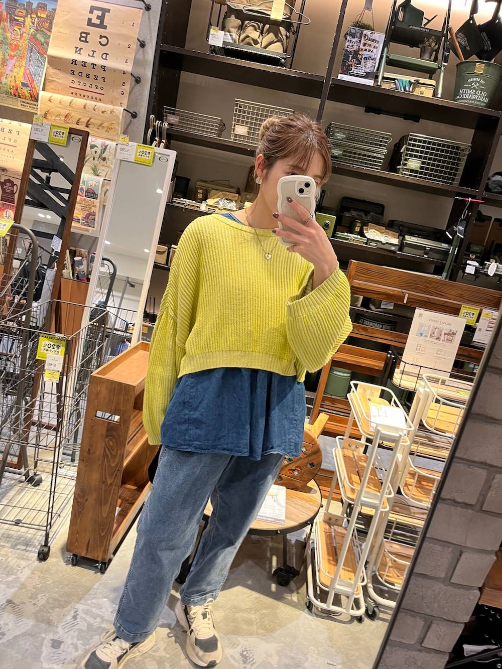 イエロー系のニット/セーター、ブルー系のその他パンツ、ホワイト系のショルダーバッグを着用したレディースの春コーディネートの6枚目の写真