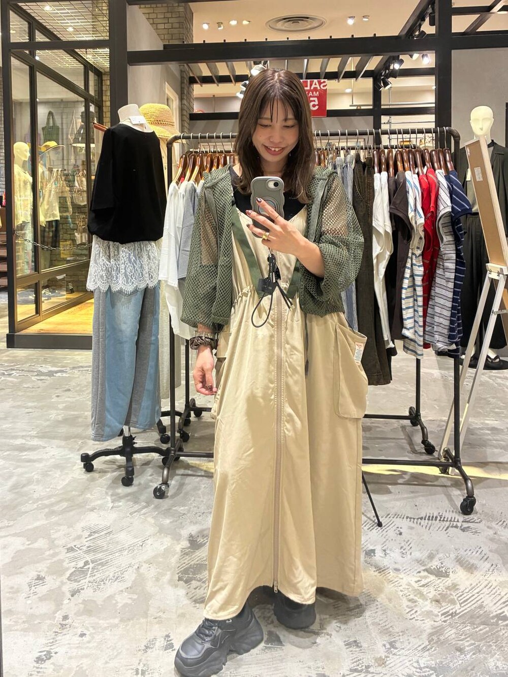 グリーン系のパーカーを着用したレディースの夏コーディネートの2枚目の写真