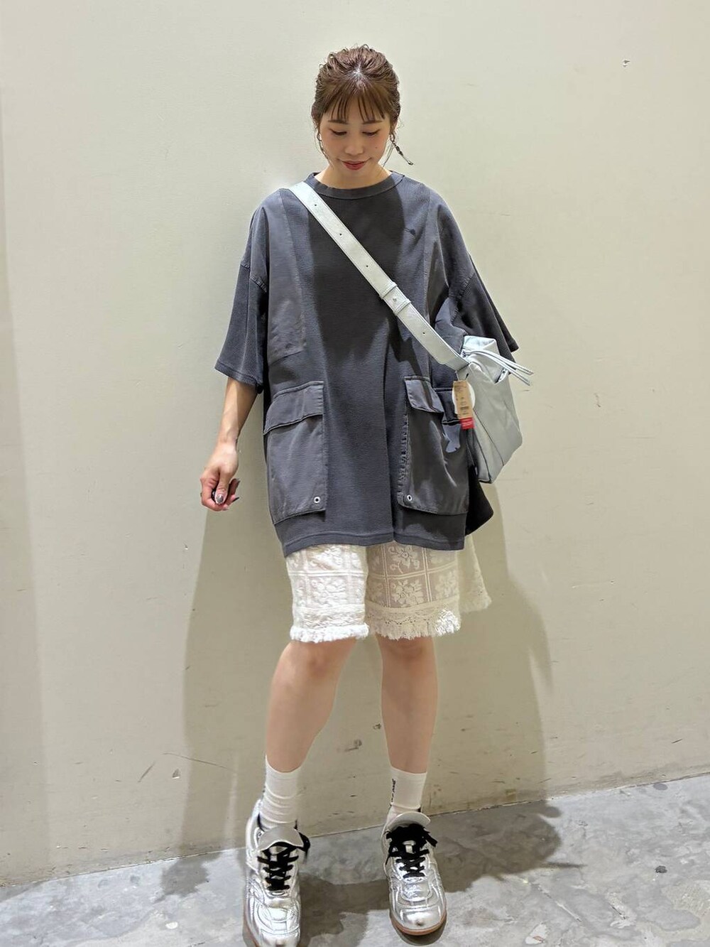 ベージュ系のその他パンツ、シルバー系のスニーカー、グレー系のショルダーバッグを着用したレディースの夏コーディネートの4枚目の写真