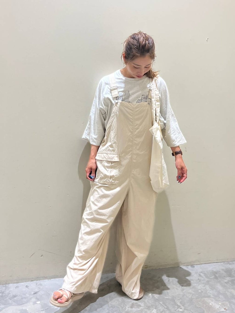 ベージュ系のサロペット/オーバーオール、ベージュ系のTシャツ/カットソー、ベージュ系のサンダルを着用したレディースの夏コーディネートの8枚目の写真