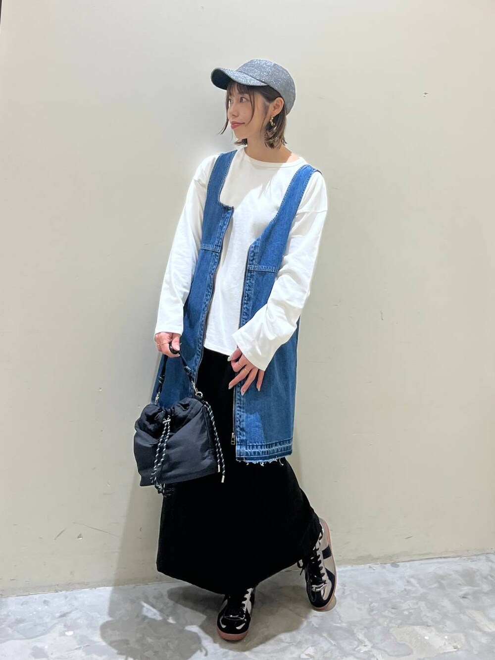 ブラック系のスカート、ブルー系のドレス、シルバー系のスニーカーを着用したレディースの冬コーディネートの2枚目の写真