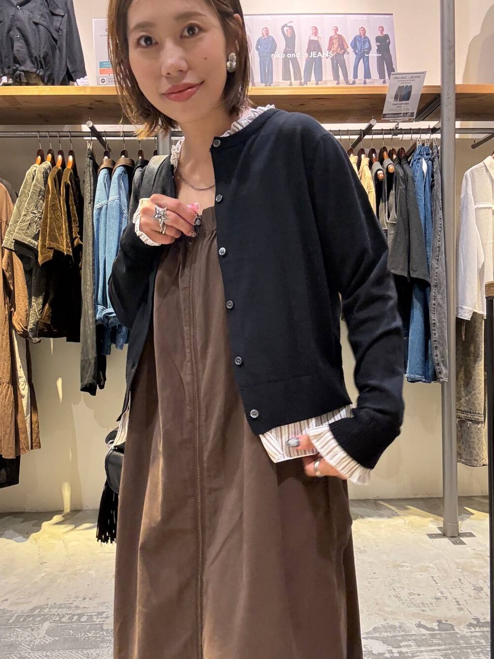 ブラック系のパンプス、ブラック系のカーディガン/ボレロ、ブラック系のショルダーバッグを着用したレディースの秋コーディネートの3枚目の写真