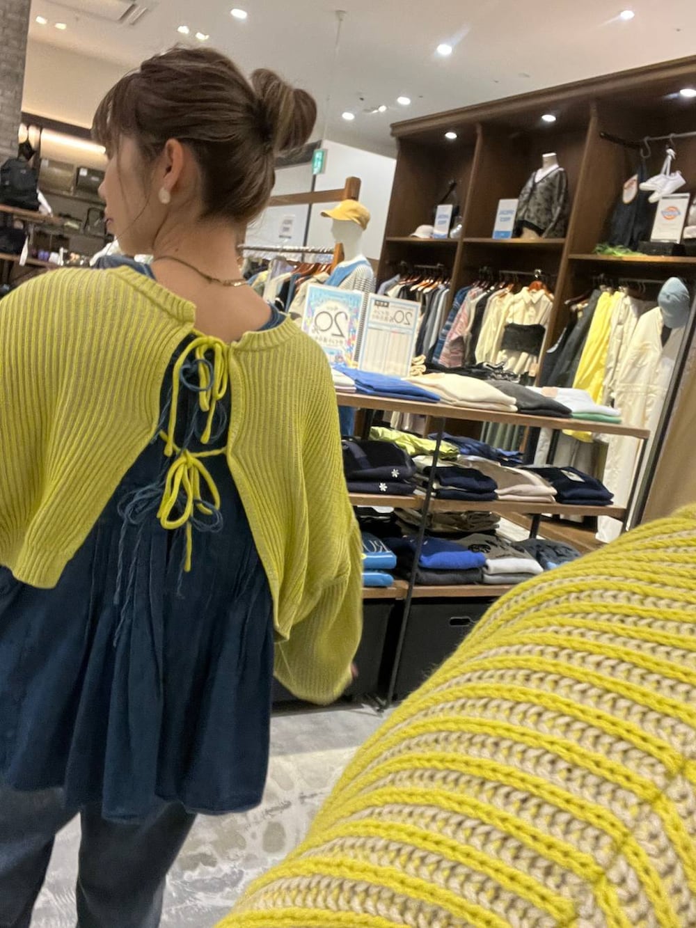 イエロー系のニット/セーター、ブルー系のその他パンツ、ホワイト系のショルダーバッグを着用したレディースの春コーディネートの5枚目の写真