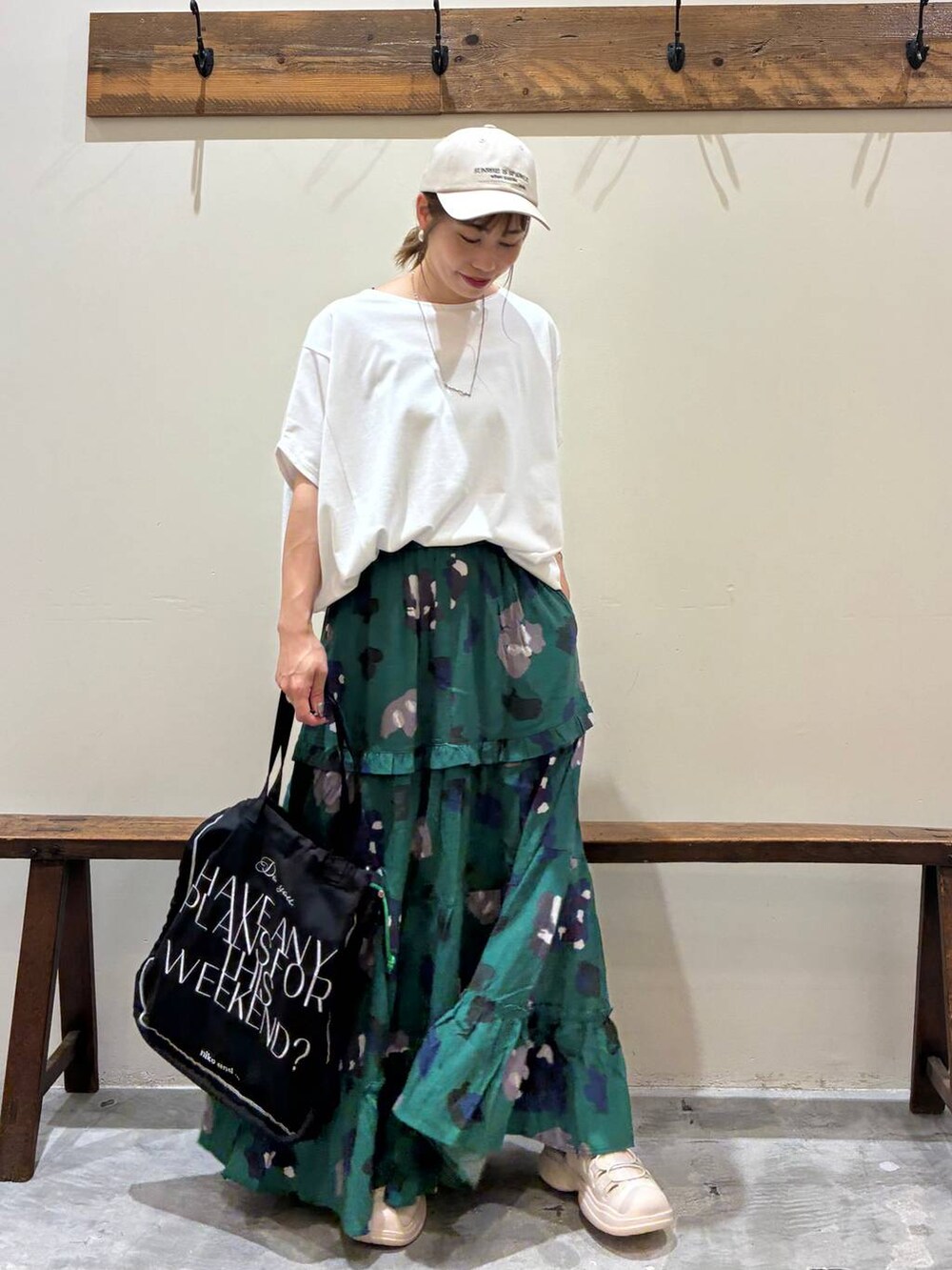 ブラック系のトートバッグ、グリーン系のスカート、ベージュ系のサンダルを着用したレディースの夏コーディネートの6枚目の写真