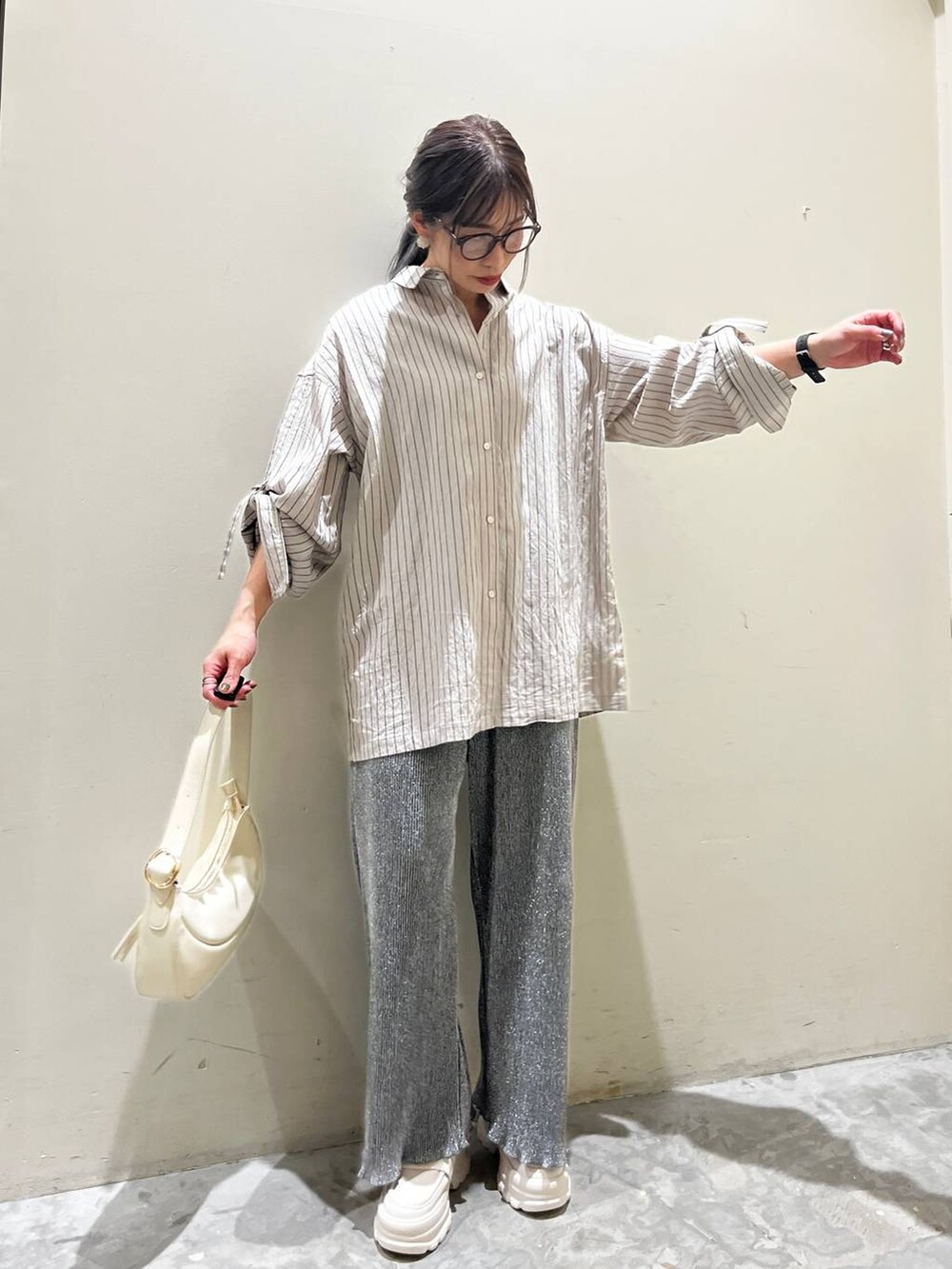 ベージュ系のショルダーバッグ、ベージュ系のローファー、グレー系のその他パンツを着用したレディースの春コーディネートの3枚目の写真