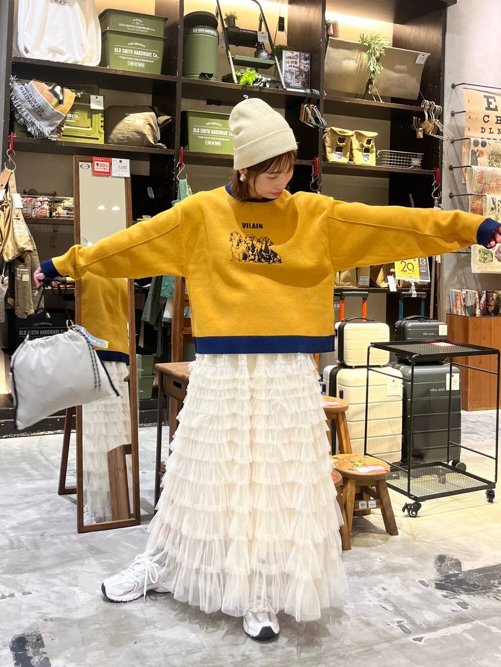 ホワイト系のスニーカー、グレー系のショルダーバッグ、ホワイト系のスカートを着用したレディースの秋コーディネートの3枚目の写真