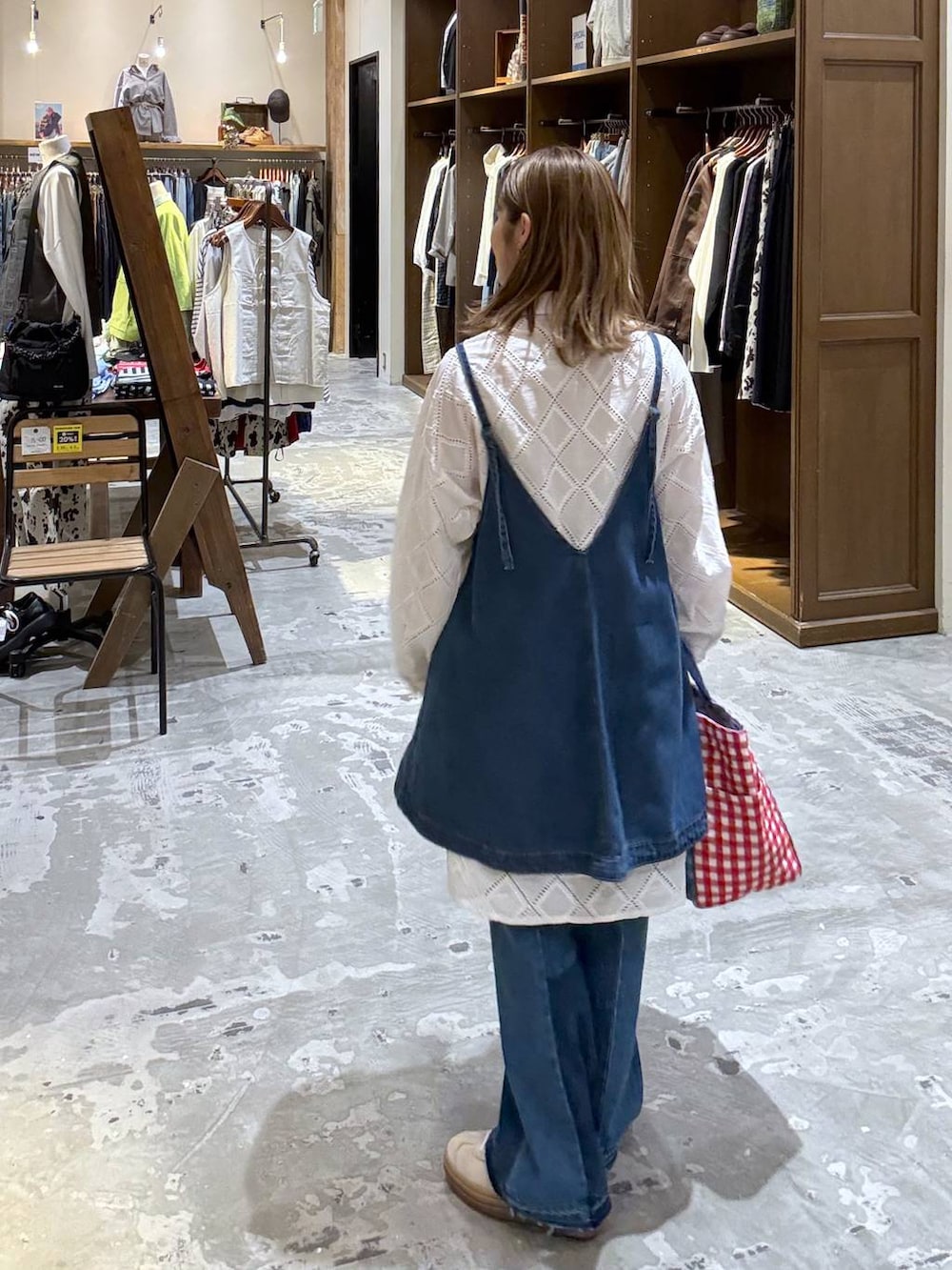 ベージュ系のスニーカー、ブルー系のデニムパンツ、ブルー系のキャミソールを着用したレディースの春コーディネートの3枚目の写真