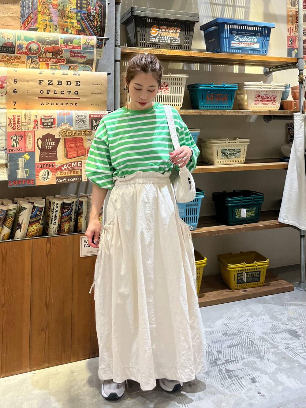 ベージュ系のスカート、ホワイト系のショルダーバッグ、グリーン系のTシャツ/カットソーを着用したレディースの春コーディネートの5枚目の写真