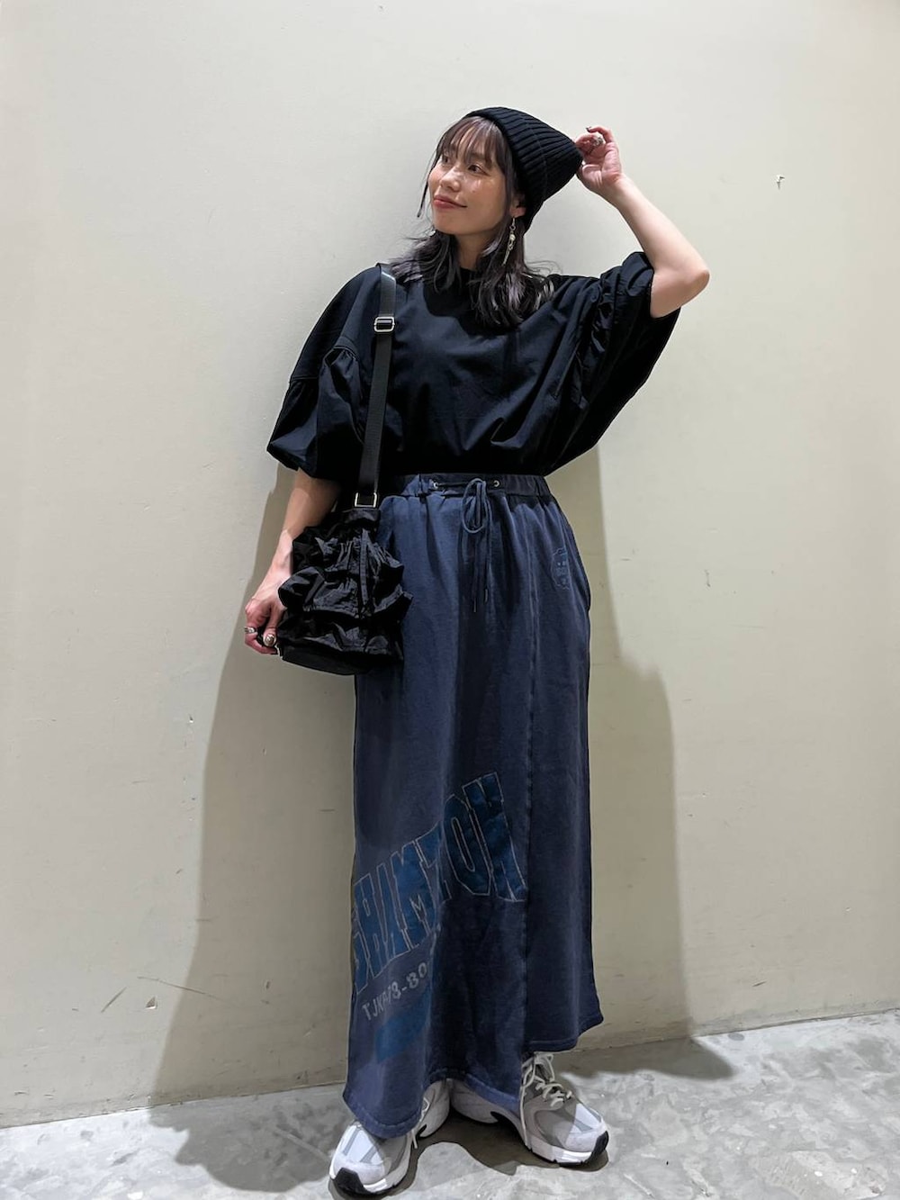 ブラック系のショルダーバッグ、ブルー系のスカート、ブラック系のシャツ/ブラウスを着用したレディースの春コーディネートの5枚目の写真