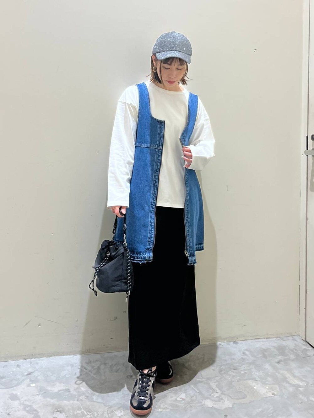 ブラック系のスカート、ブルー系のドレス、シルバー系のスニーカーを着用したレディースの冬コーディネートの5枚目の写真