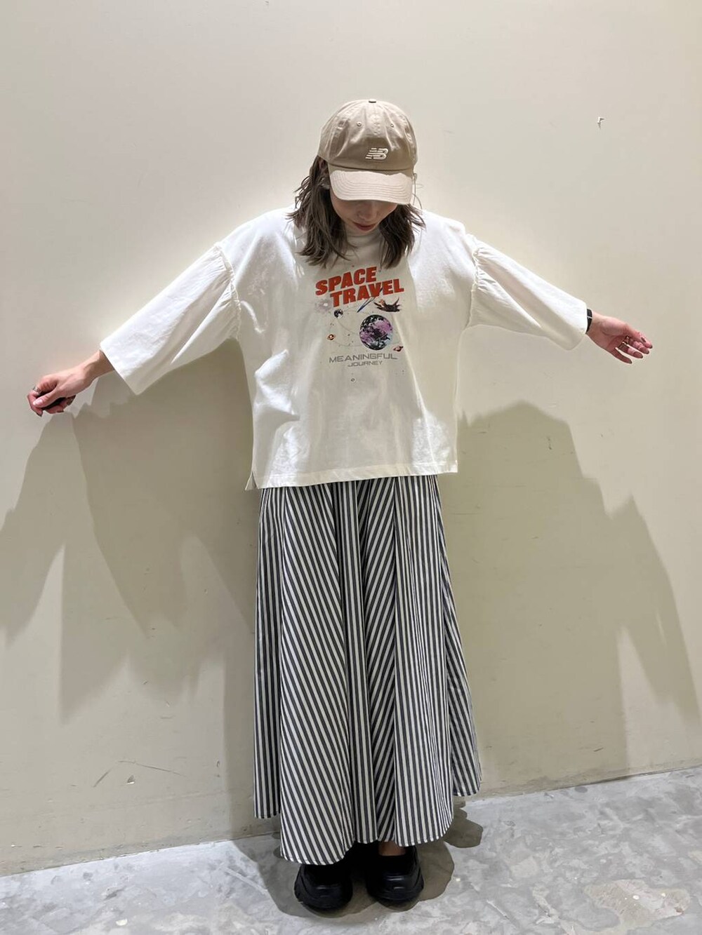 ホワイト系のTシャツ/カットソー、ブルー系のスカート、ブラック系のスニーカーを着用したレディースの春コーディネートの2枚目の写真