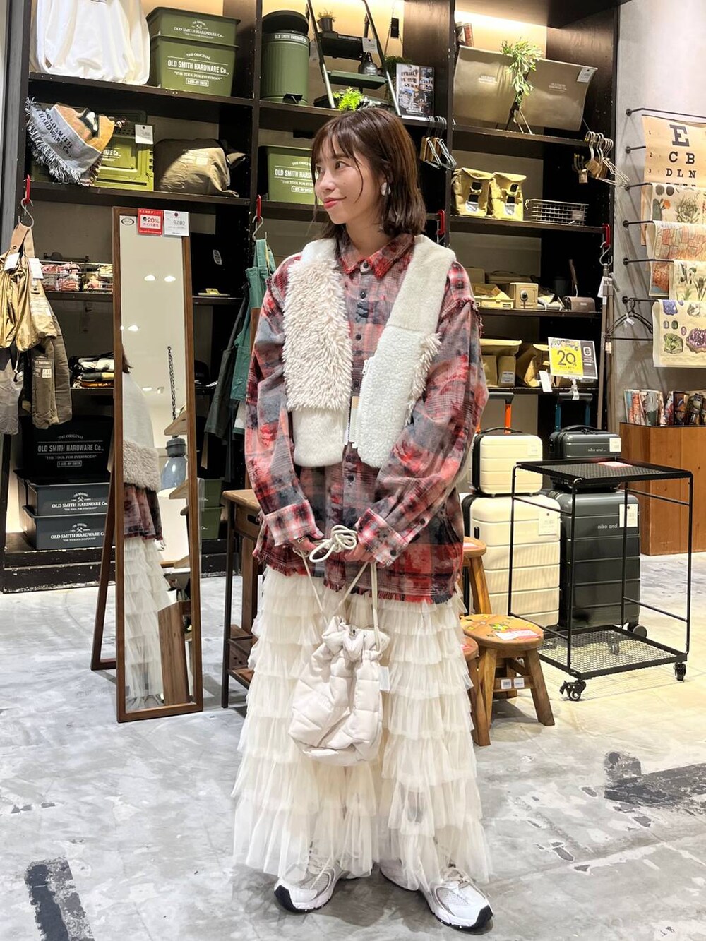 ホワイト系のスニーカー、レッド系のシャツ/ブラウス、ベージュ系のベストを着用したレディースの秋コーディネートの3枚目の写真