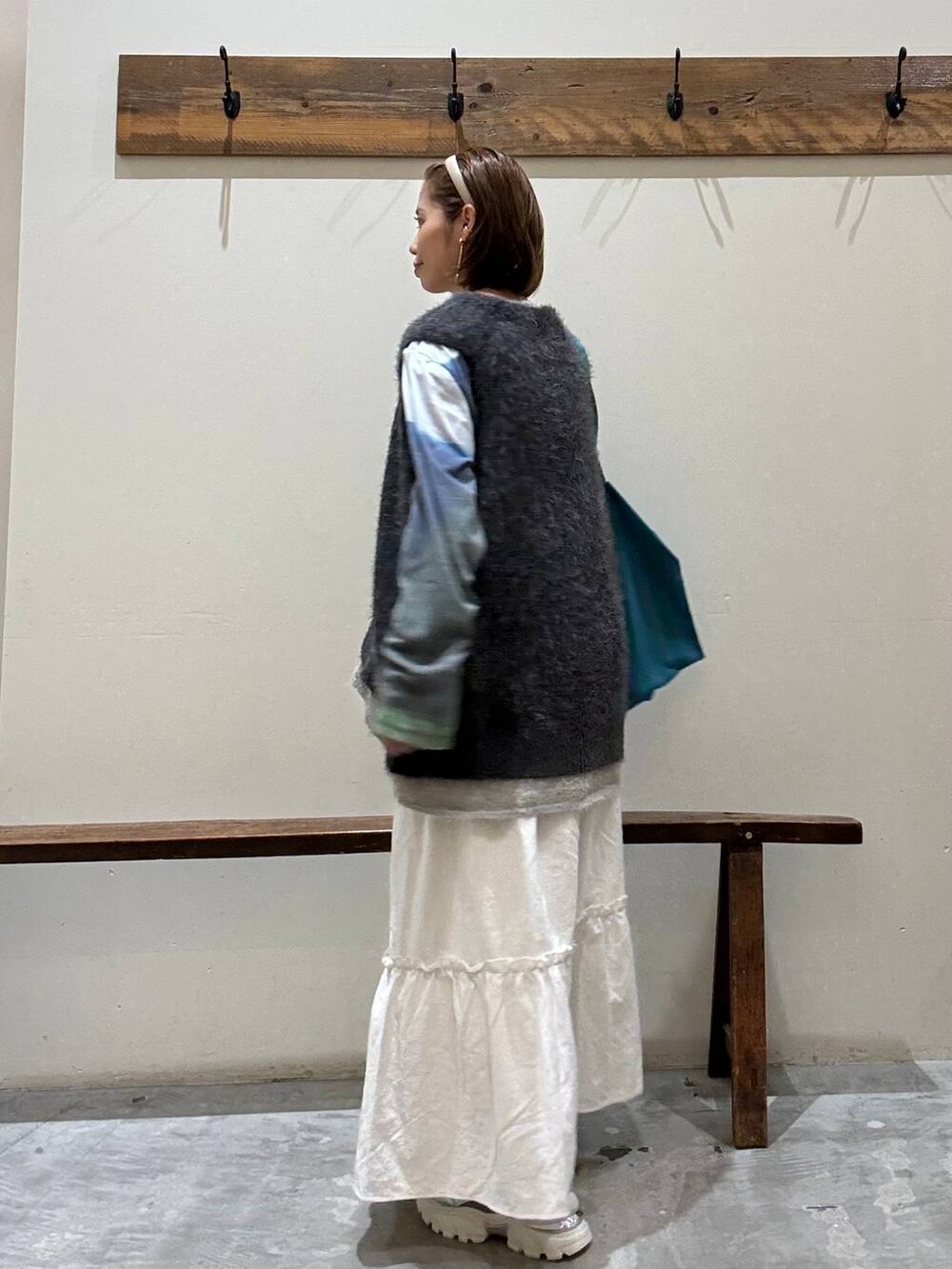 シルバー系のスニーカー、その他のトートバッグ、ベージュ系のスカートを着用したレディースの秋コーディネートの4枚目の写真