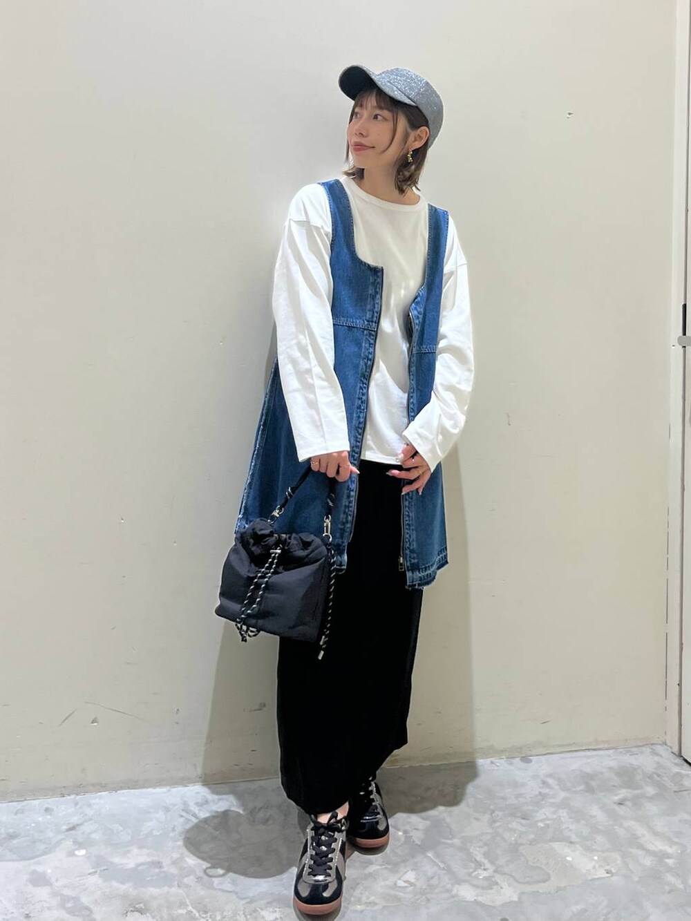 ブラック系のスカート、ブルー系のドレス、シルバー系のスニーカーを着用したレディースの冬コーディネートの4枚目の写真